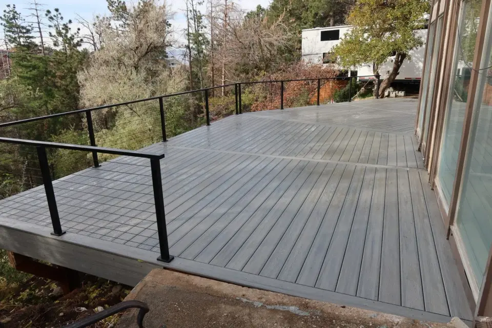 Finished gray composite deck with clean borders and black cable railings