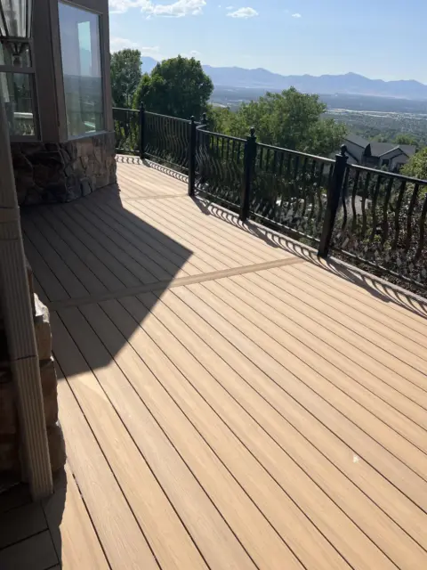 Completed wood-tone composite deck with a view across the Utah valley